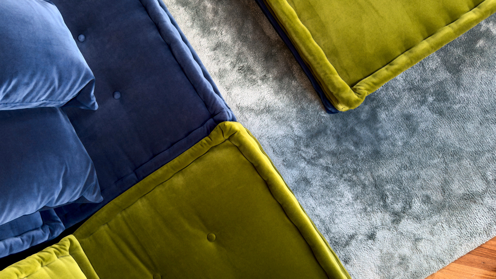 Overhead view of blue and chartreuse velvet seating around a pale textured rug