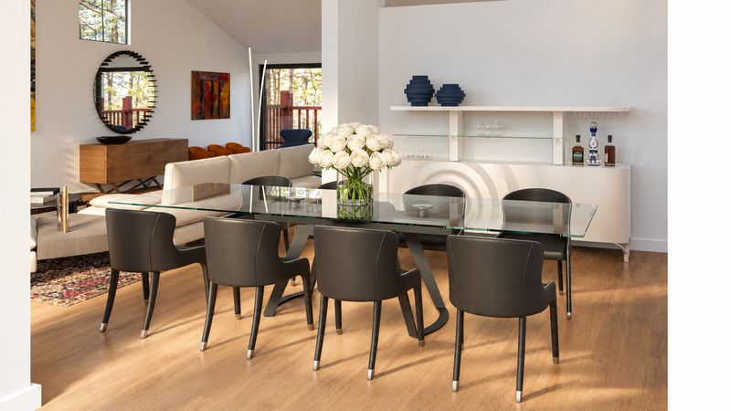 Dining table with dark chairs and a white sofa beyond, design visualization