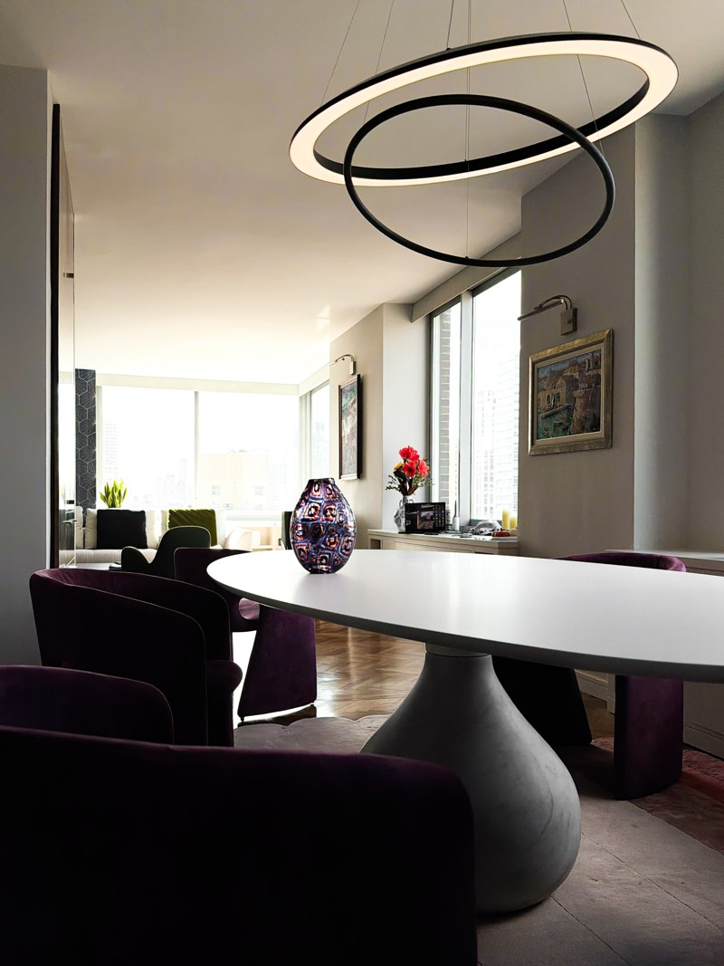 Dining table beneath sculptural ring lighting