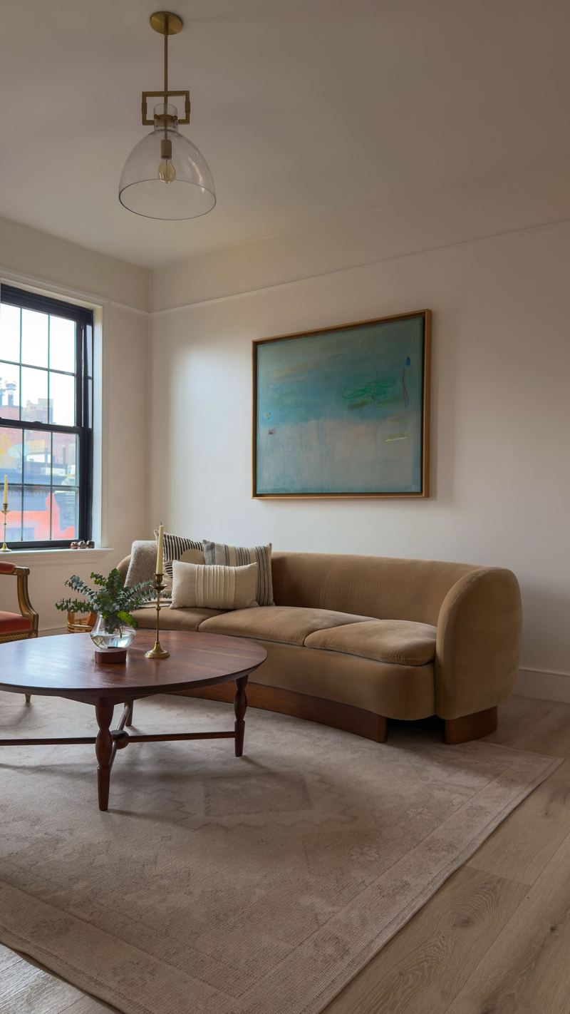 Living room with a round wood coffee table, West Village Condominium